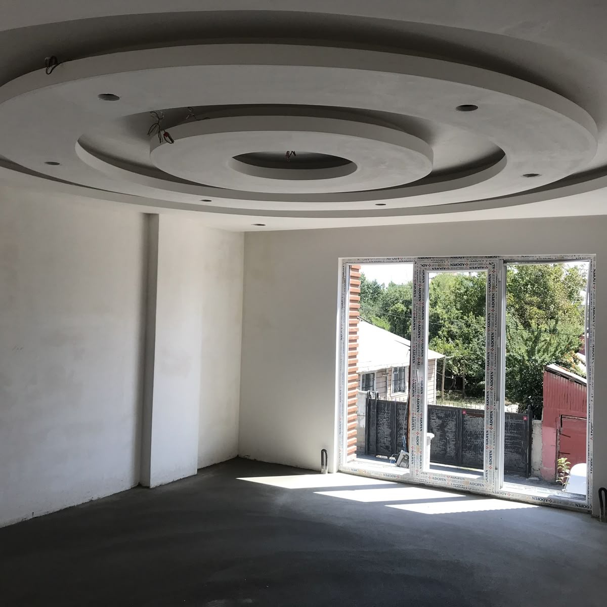 Circular ringed POP ceiling design in an unfinished living room