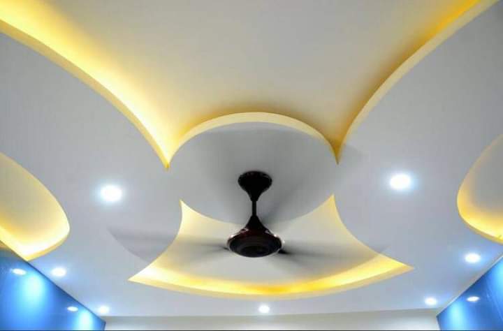 Curved POP ceiling with yellow cove lighting around a ceiling fan